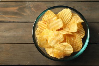 Ahşap masada leziz patates cipsleri, üst manzara. Metin için boşluk