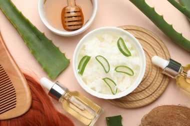 Hindistan cevizi, tereyağı talaşı, bal, tarak, saç kilidi, kozmetik ürün ve bej arka planda aloe yaprakları, düz yatak