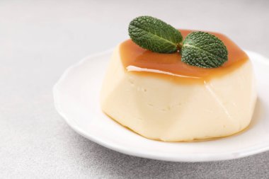 Karamel soslu lezzetli puding ve nane şekeri, yakın plan.