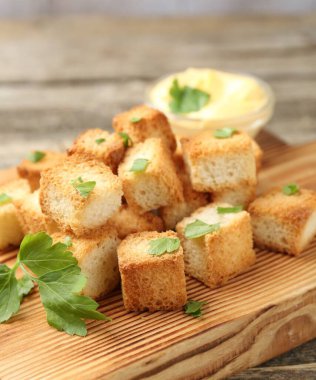 Tahta masada maydanoz ve sos dilimlenmiş çıtır çıtır ekmek, yakın plan.