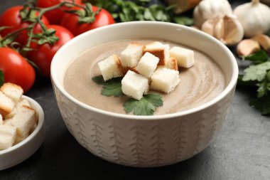 Ekmek arası mantar kremalı çorba, maydanoz ve siyah desenli masa malzemeleri, yakın plan.