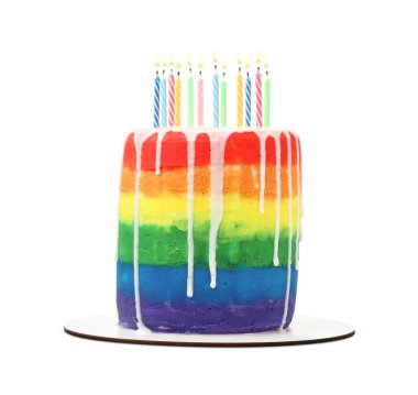 Beyaz arka planda mumları olan nefis gökkuşağı pastası.