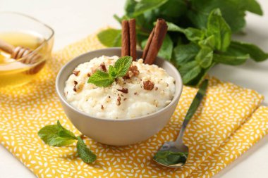 Cevizli, tarçınlı, nane ve ballı leziz sütlaç, yakın plan.