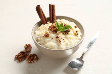 Cevizli, tarçınlı, nane ve kaşıklı leziz sütlaç, yakın plan.