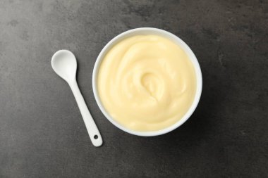 Siyah masadaki kaşıklı vanilyalı puding.