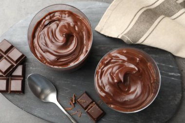 Lezzetli puding ve çikolata parçaları gri masada, düz yatıyordu.