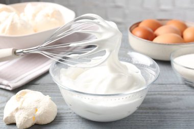 Krem şantili çırpma çırpma ve gri ahşap masadaki diğer malzemeler, yakın plan. Kurabiye pişiriyorum.