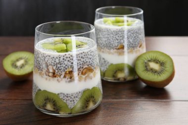 Chia tohumlu lezzetli tatlı, yoğurt, tahıl gevreği ve ahşap masada kivi, yakın plan. Süper yemek.