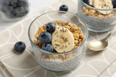 Chia tohumlu lezzetli tatlı, yoğurt, granola, yaban mersini ve muz, yakın plan. Süper yemek.