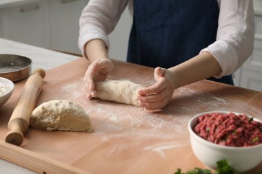 Khinkali yapıyorum. Mutfakta hamur yoğuran kadın, yakın plan.