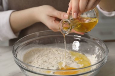 Khinkali yapıyorum. Kadın mutfaktaki masada kaseye yağ koyuyor, yakın plan.