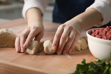Khinkali yapıyorum. Kadın mutfaktaki masada hamur paylaştırıyor, yakın plan.