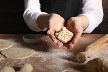 Mutfaktaki masada khinkali yapan kadın, yakın plan.