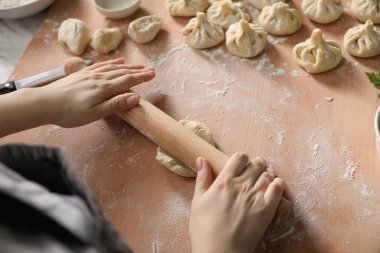 Kadın mutfaktaki masada khinkali yapıyor.