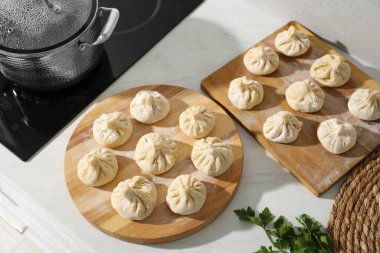 Mutfaktaki tezgahın üstünde otlu ve pişmemiş khinkali var.