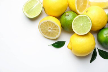 Beyaz arka planda taze limonlar ve limonlar, yakın plan. Metin için boşluk