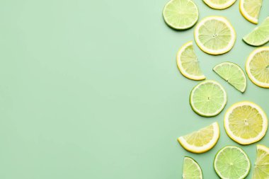 Dilimlenmiş taze limon ve limon soluk yeşil arka planda, düz yerde. Metin için boşluk