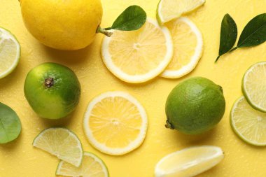 Taze limon, limon ve yeşil yapraklar sarı arka planda, düz yerde