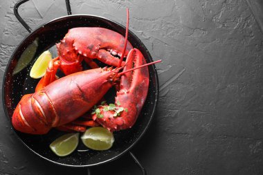 Lezzetli haşlanmış ıstakoz, limon parçaları ve siyah masa üzerinde mikroyeşiller, üst manzara. Metin için boşluk