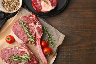 Çiğ et parçaları, domates ve baharatlar ahşap masada, düz yerde. Metin için boşluk