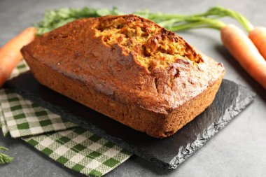 Gri desenli masada havuçlu kek ve sebzeler, yakın plan.