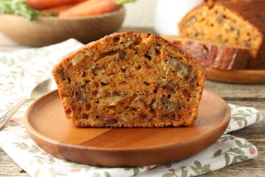 Ev yapımı havuçlu kek, fındıklı ve kaşıkla ahşap masa, yakın plan.