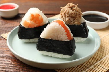 Lezzetli onigiri (Japon pirinç topları) ahşap masada servis edilir, yakın plan.