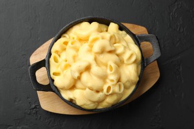 Siyah masanın üstünde nefis peynirli makarna.