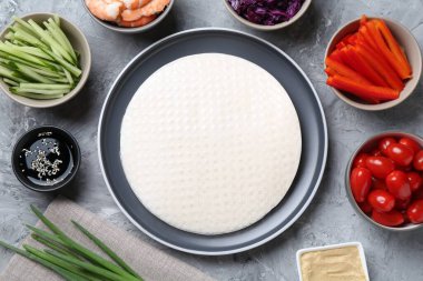 Pirinç kağıt çarşaflar ve açık gri masa üzerindeki farklı malzemeler, düz uzanmış.