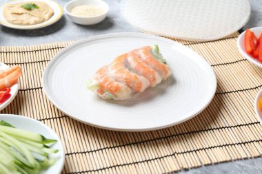 Çin böreği. Açık gri masa üzerinde farklı malzemeler içeren pirinç kağıdı, yakın plan.