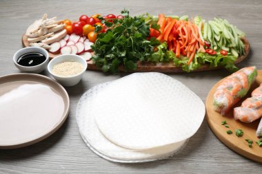 Pirinç kağıt çarşaflar ve gri ahşap masa üzerindeki farklı malzemeler. Yakın plan.