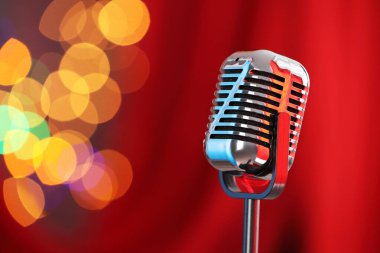 Kırmızı perdeye karşı bir klasik mikrofon, mesaj için yer. Bokeh etkisi