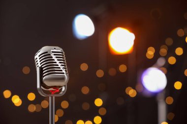 Karanlık arka plana karşı bir klasik mikrofon, mesaj için boşluk. Bokeh etkisi