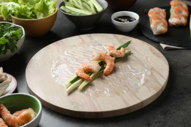 Pilav kağıtları ve koyu gri masa üzerindeki farklı malzemeler, yakın plan.