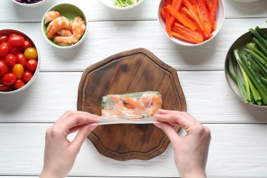 Beyaz ahşap masada nefis börek yapan bir kadın.