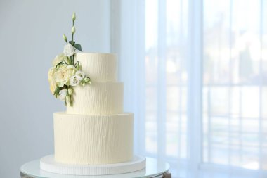 İçerideki masada çiçek desenli nefis düğün pastası, mesaj için yer var.