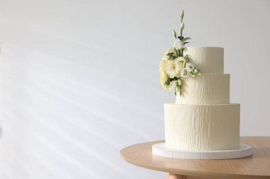 İçerideki ahşap masada çiçek desenli nefis düğün pastası, mesaj için yer.