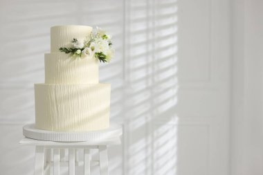 İçerideki masada çiçek desenli nefis düğün pastası, mesaj için yer var.