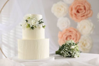 Çiçekli düğün pastası ve kapalı masa desenli lezzetli bir pasta.