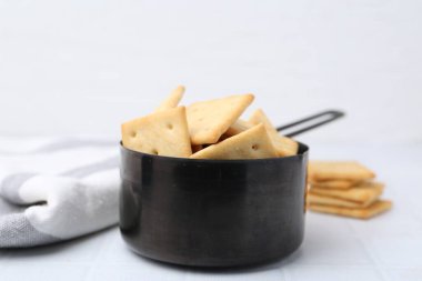 Beyaz fayanslı masada lezzetli tuzlu krakerler, yakın plan.