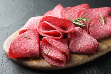 Siyah masada servis edilen biberiyeli lezzetli sosis dilimleri, yakın plan.