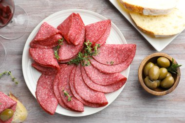 Dilimler dolusu lezzetli sosis ve kekik hafif ahşap masada servis edilir.