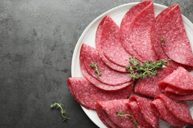 Gri masada servis edilen kekikli lezzetli sosis dilimleri, üst manzara. Metin için boşluk