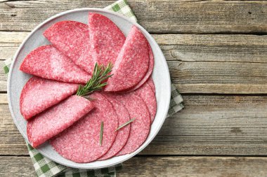 Ahşap masada servis edilen biberiyeli leziz sosis dilimleri.