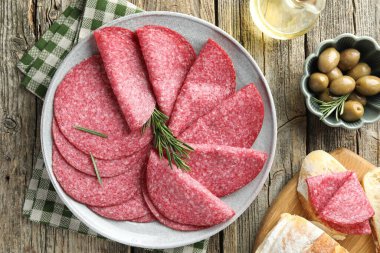 Tahta masada servis edilen biberiyeli leziz sosis dilimleri.