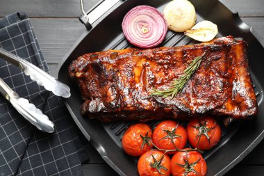 Biberiyeli domuz pirzolası, domates ve soğan. Gri ahşap masa, üst manzara.