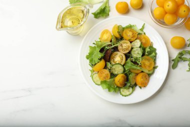 Beyaz masada sarı domatesli taze salata. Metin için boşluk