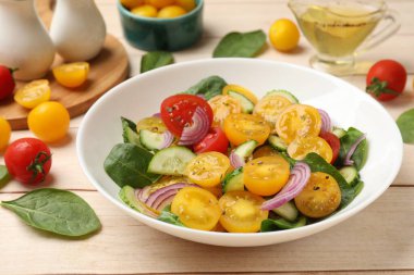 Tahta masada servis edilen sarı domatesli taze salata, yakın plan.