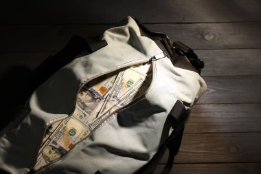 Tahta masanın üzerinde dolar banknotları olan çanta, üst manzara. Metin için boşluk