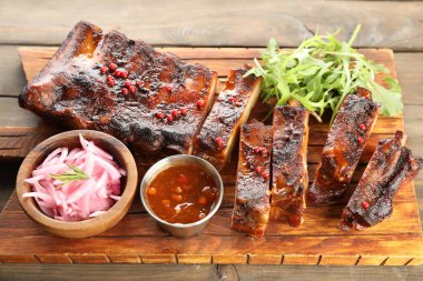 Lezzetli pirzola, soğan, sos ve roka.